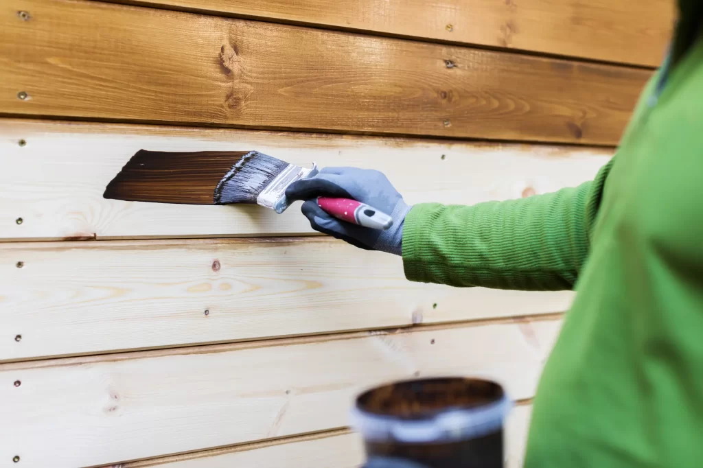 Pittura su legno con pennello e impregnante marrone